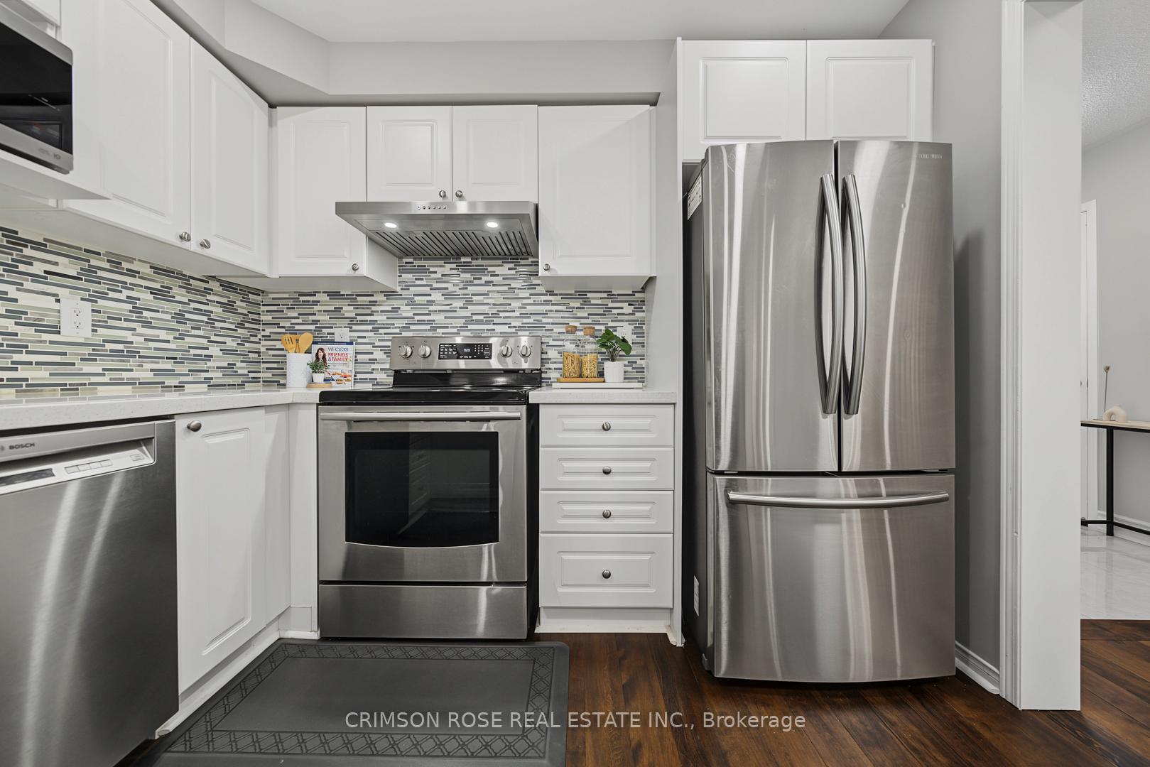 Kitchen with white cabinets, a mosaic tile backsplash, and stainless steel appliances.