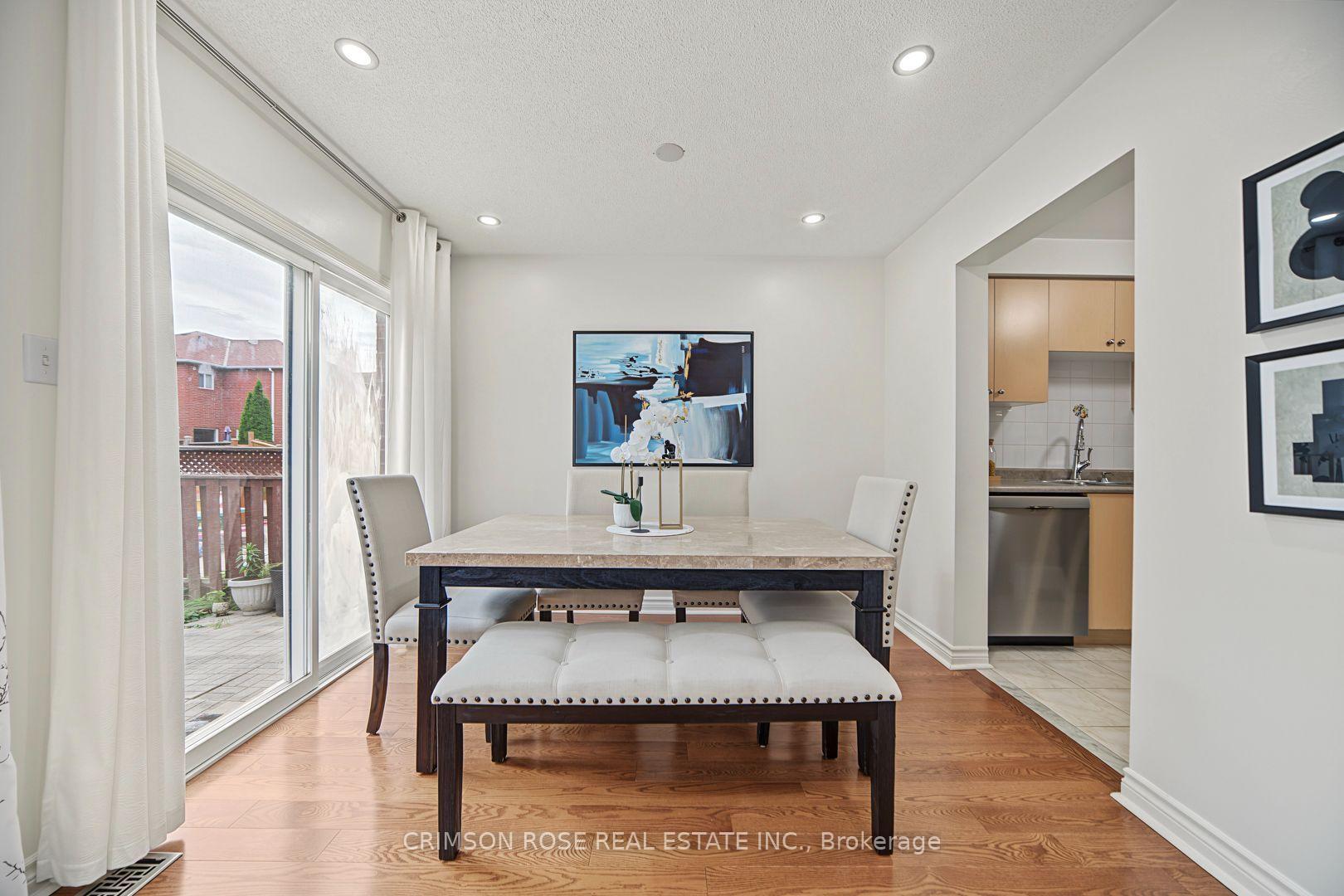 Dining area with a marble-look table, upholstered seating, hardwood floors, and a sliding glass door to the deck.