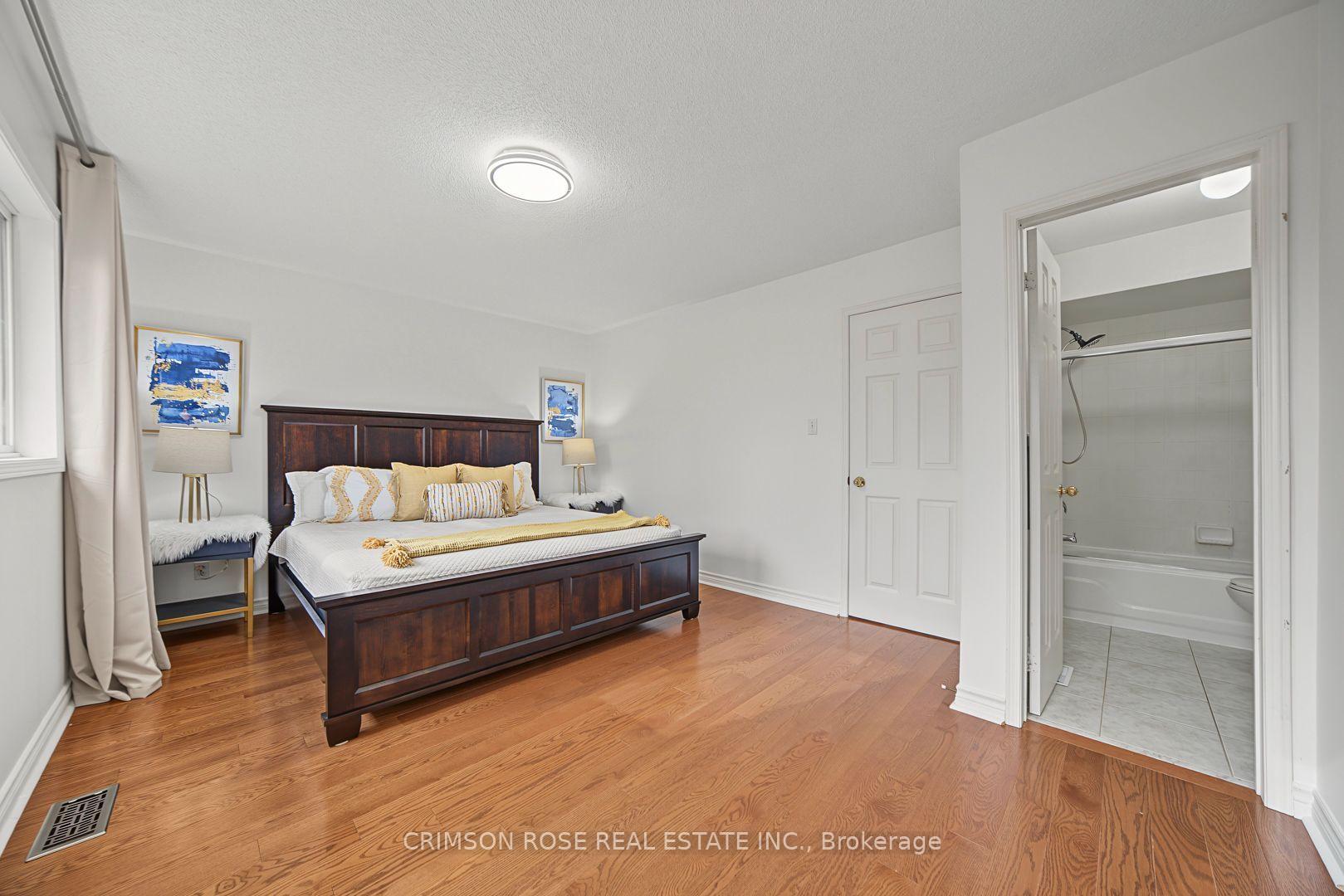 Bedroom with a dark wood bed, hardwood floors, and an adjoining bathroom.