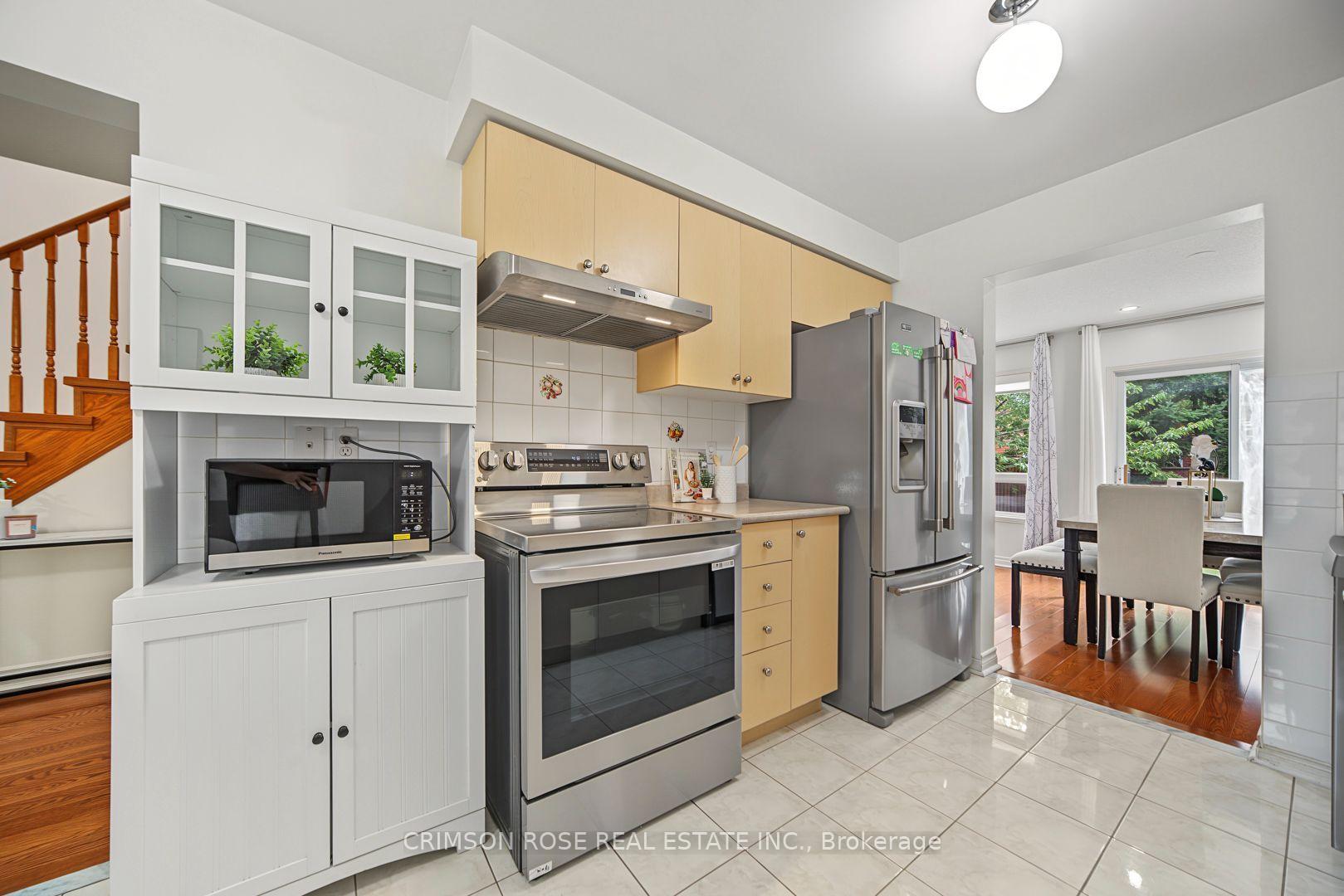 Kitchen with pale wood cabinets, stainless steel appliances, and an adjoining dining area.