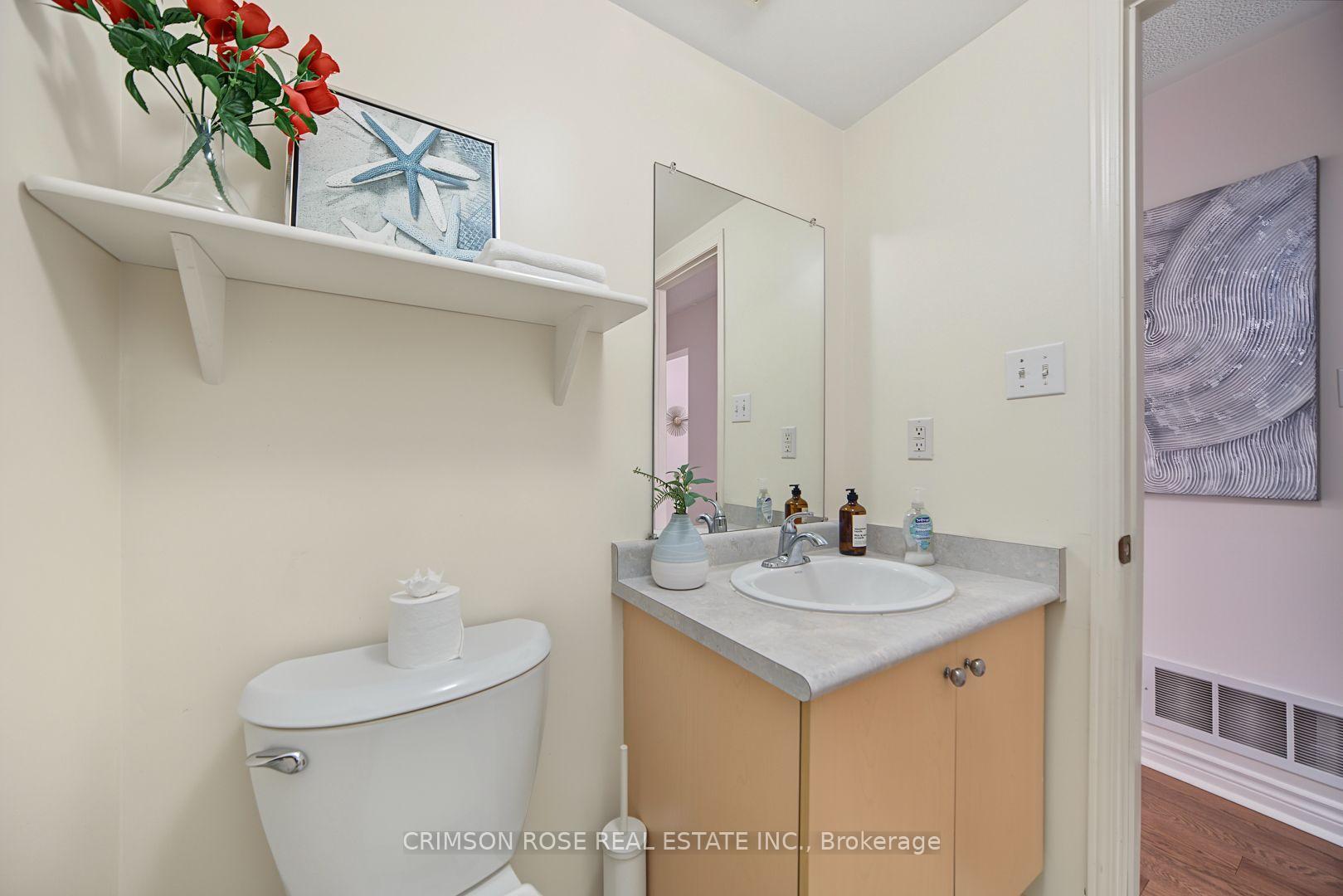 Bathroom with a light wood vanity, gray countertop, oval sink, and wall mirror.