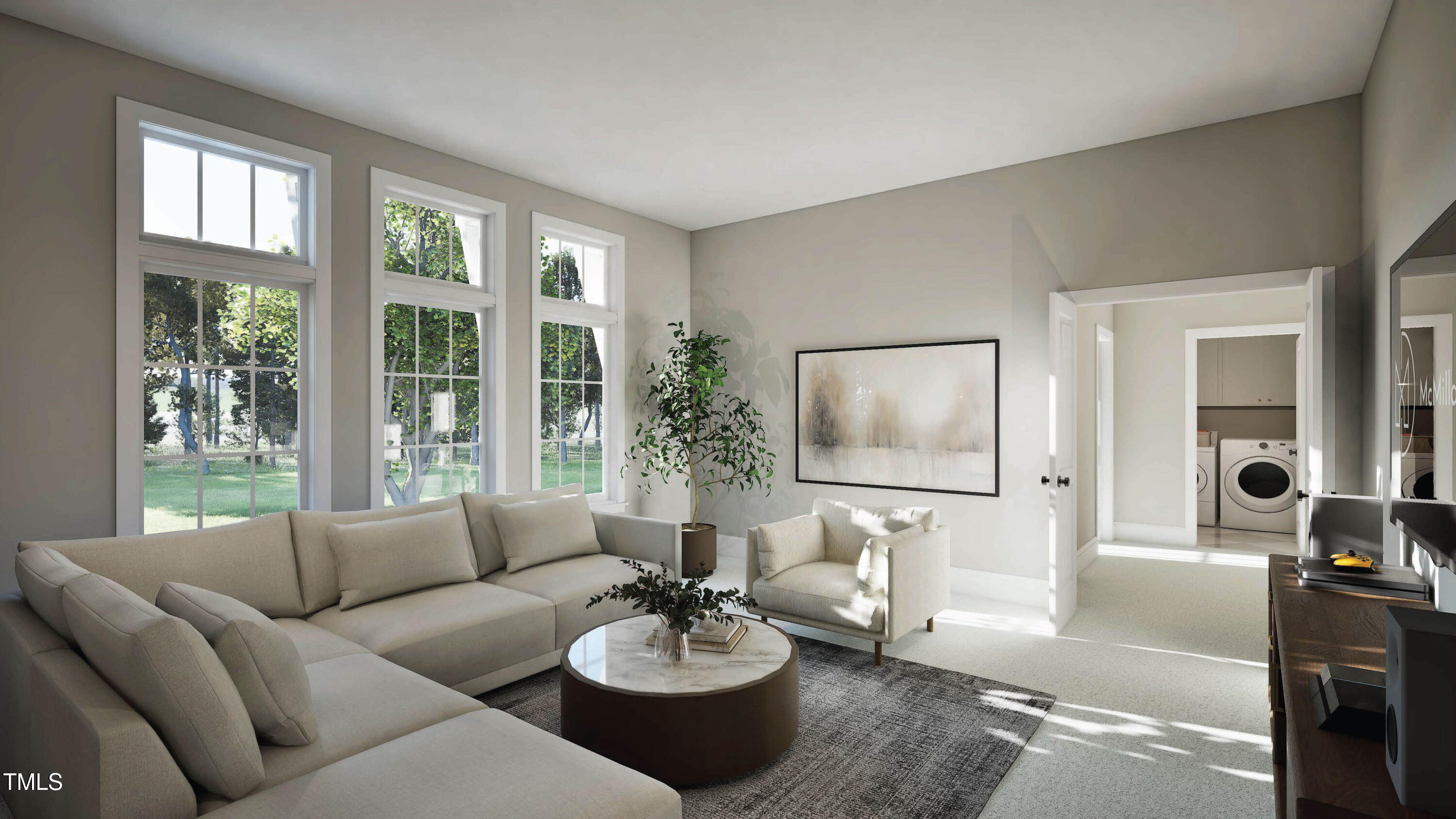 Bright living room with tall windows, a light sectional, and a doorway to the laundry area.