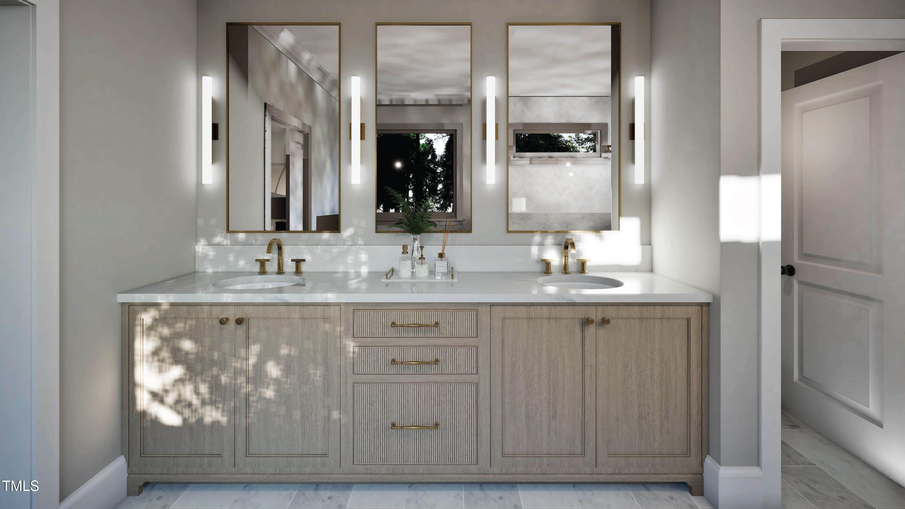 Bathroom double vanity with brass faucets, light wood cabinetry, and three framed mirrors.