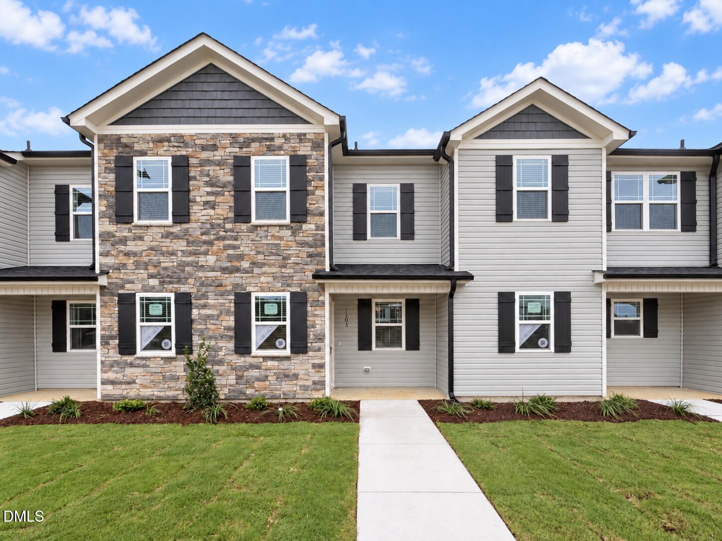 Front exterior of 1203 Brookrun Drive in Oxford, NC, featuring a stone facade, black shutters, and a covered front porch.