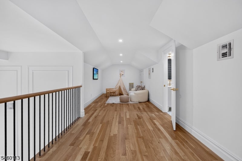 Upstairs landing with vaulted ceiling, hardwood floors and a small play nook at the far end.