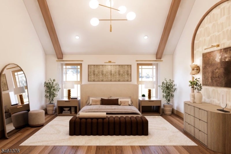 Furnished bedroom with a vaulted wood-beam ceiling, centered bed, and tall windows.