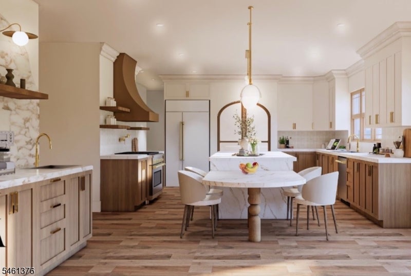 Bright kitchen with a marble island, custom wood cabinetry, and a round dining table.