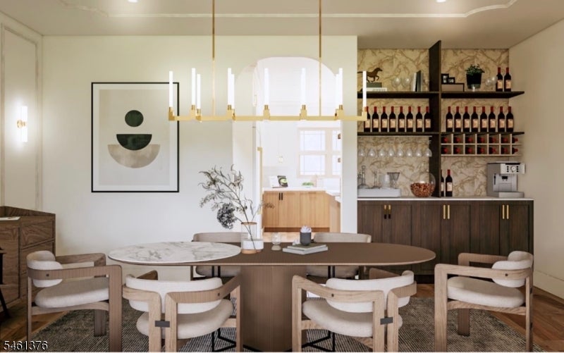 Dining room with an oval table, upholstered chairs, and built-in wine storage.