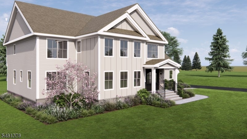 Two-story house with steep gabled roofs, a covered entrance, and landscaped flower beds.