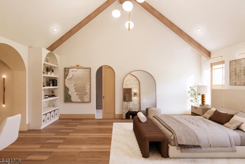Staged bedroom with a vaulted wood-beam ceiling, large bed, and arched doorways.