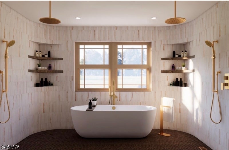 Bathroom with a freestanding soaking tub, two windows, pale tile, and brass shower fixtures.