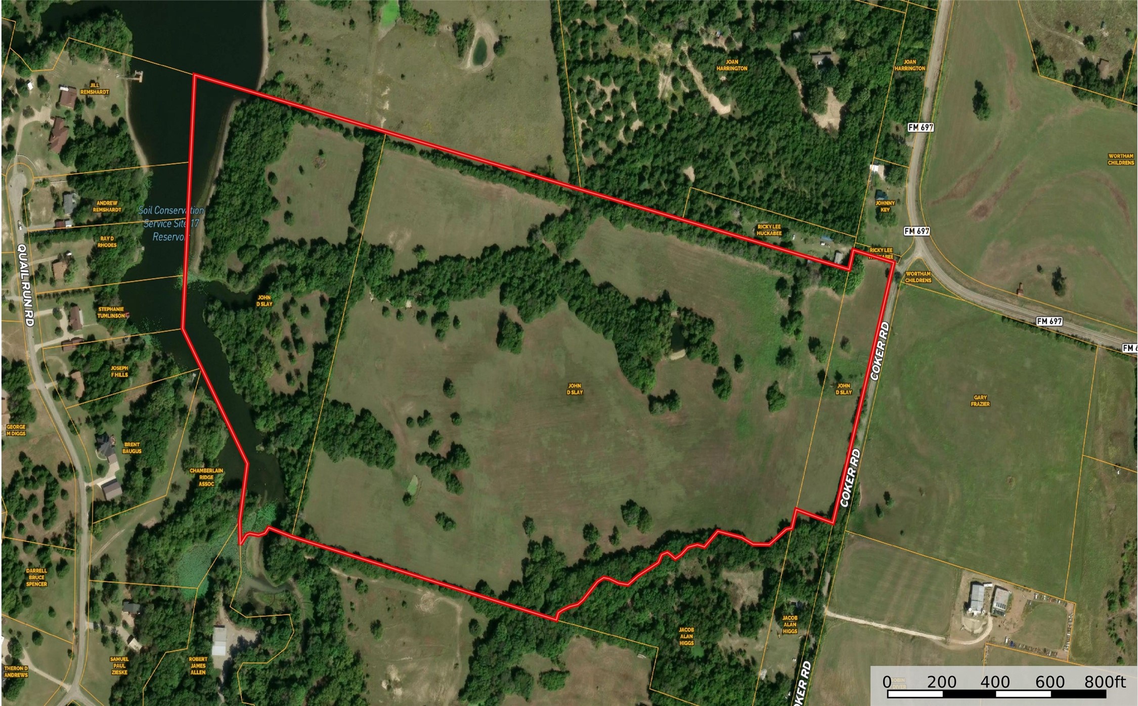 Aerial view of a red-outlined pasture property with wooded areas and water along its western edge.