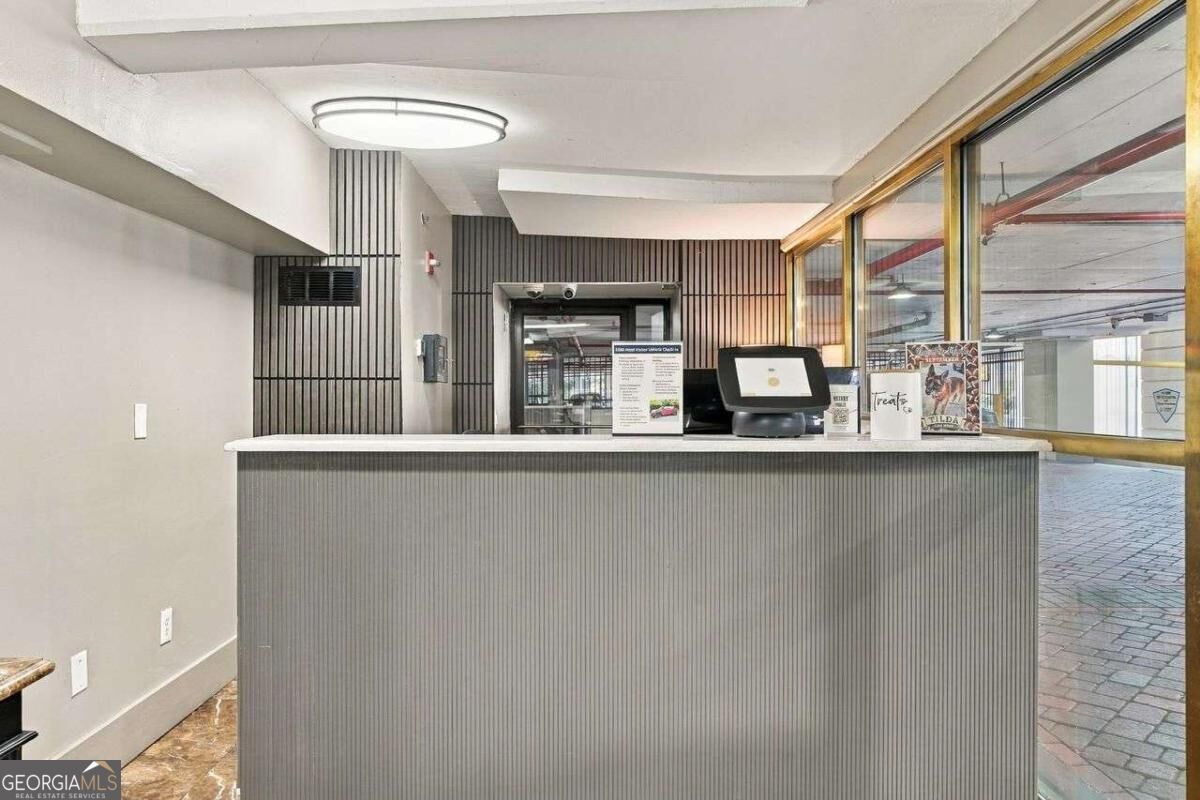 Condominium lobby with a gray reception desk and large glass windows.