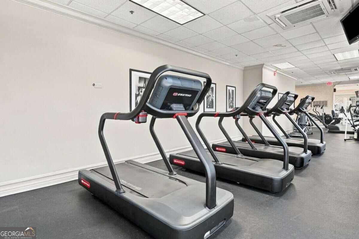 Fitness center with a row of treadmills and additional cardio equipment.
