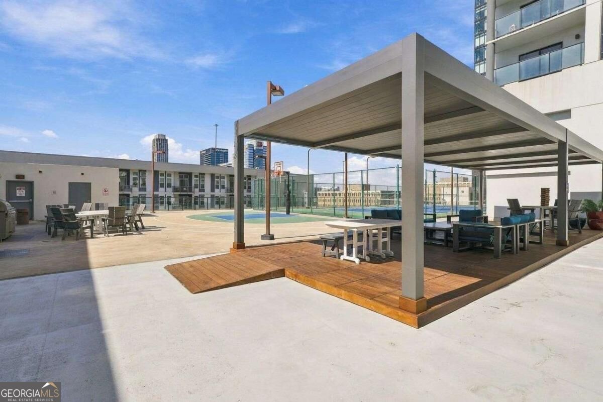 Rooftop terrace with a covered pavilion, lounge seating, and a basketball court.