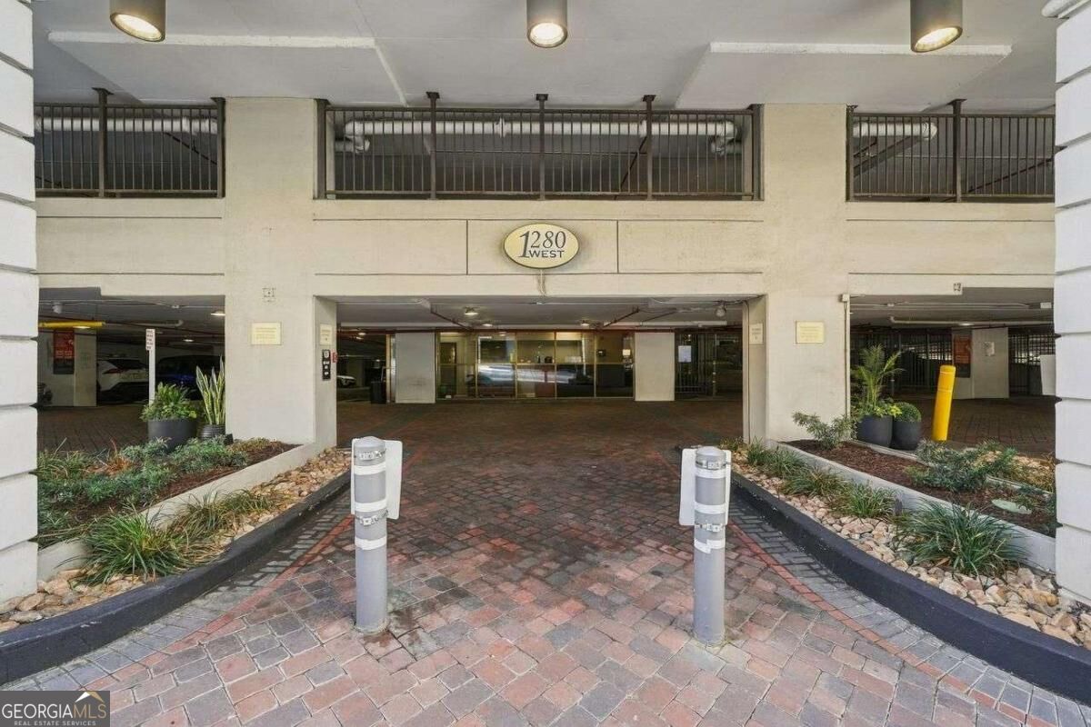 Entrance to 1280 West condominium with a covered brick drive and landscaped planters.