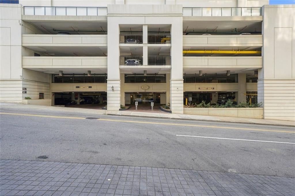 Building exterior with a central entrance beneath several levels of open parking.