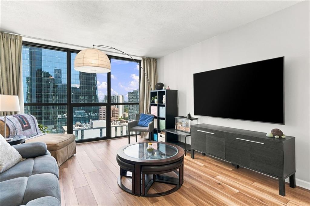 High-rise living room with floor-to-ceiling windows overlooking the city skyline.