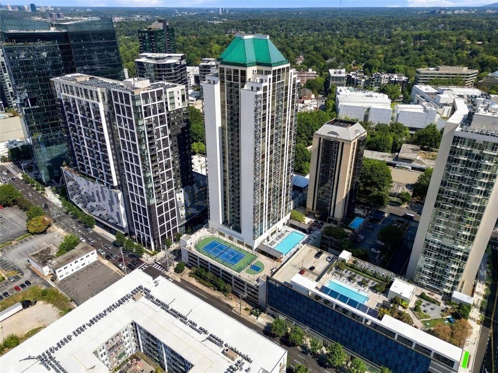Aerial view of a high-rise condominium with a green roof and rooftop pools.