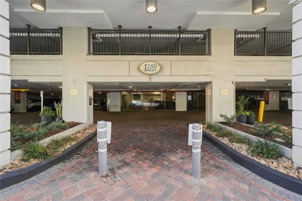 1280 West building entrance with a covered brick driveway and landscaped planting beds.