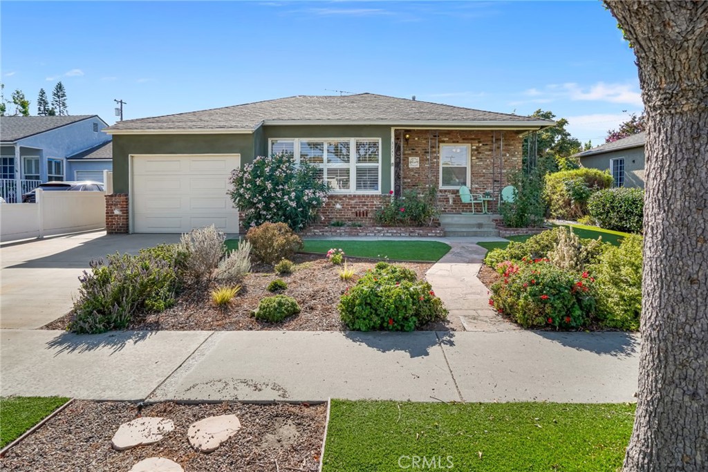 Single-story home with a brick facade, attached garage, and landscaped front yard.