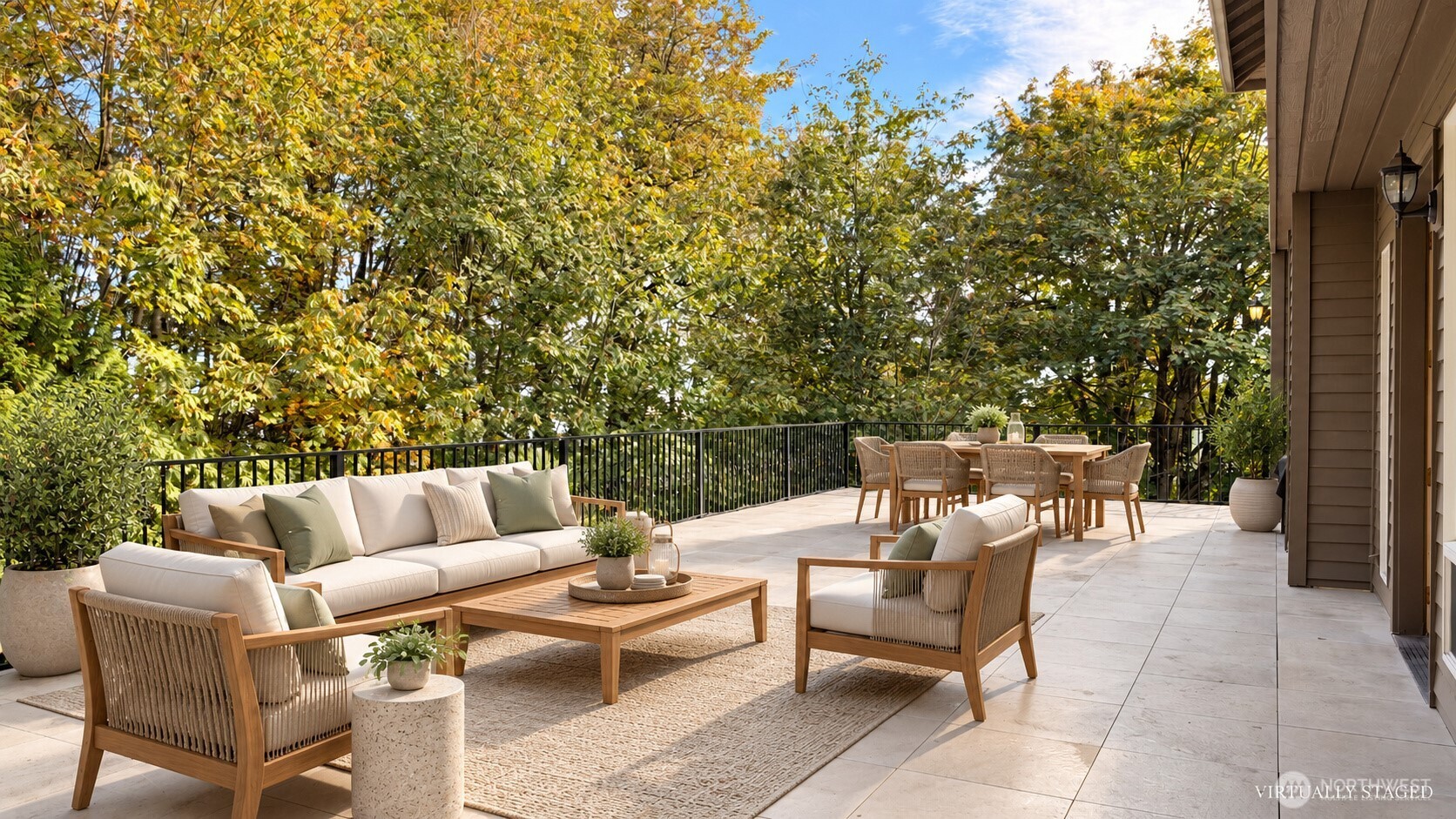 Staged patio with tiled terrace, outdoor lounge seating, and dining table beneath leafy trees.