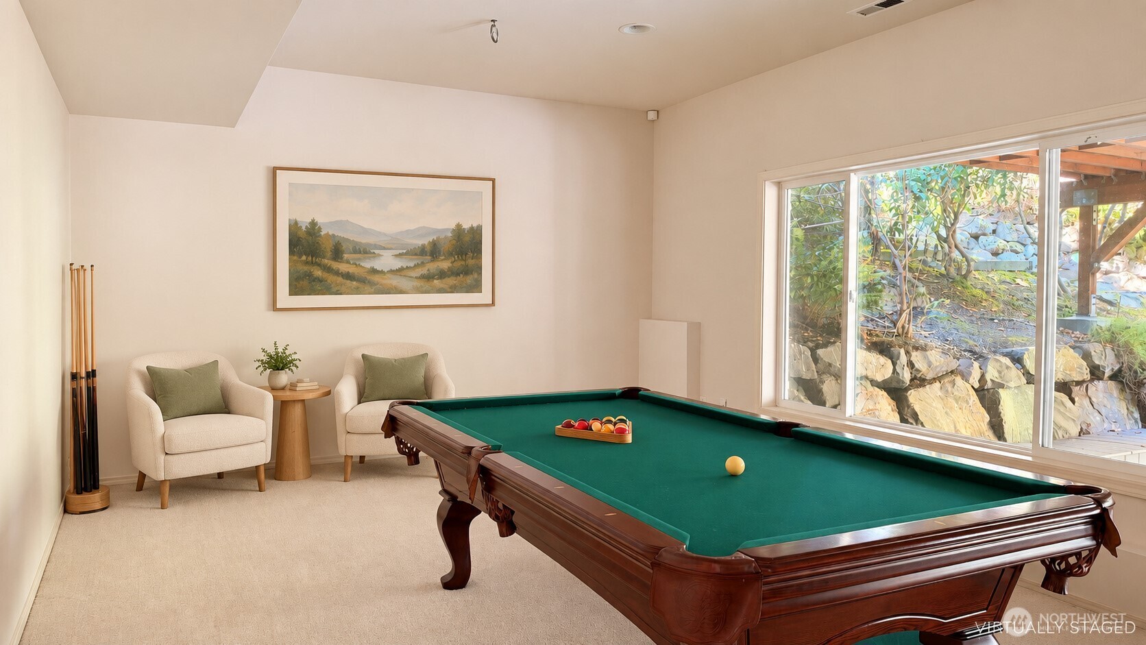 Game room with a green-felt pool table, two chairs, and large windows overlooking the yard.