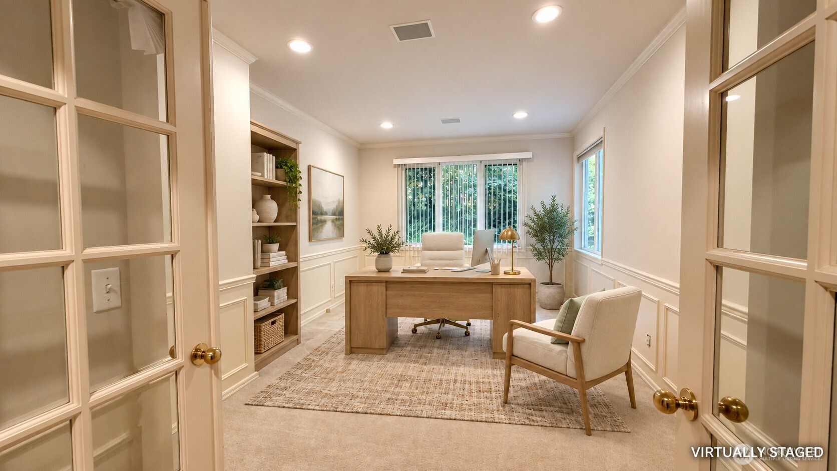 Virtually staged home office with a wood desk, built-in shelves, and glass-paneled double doors.