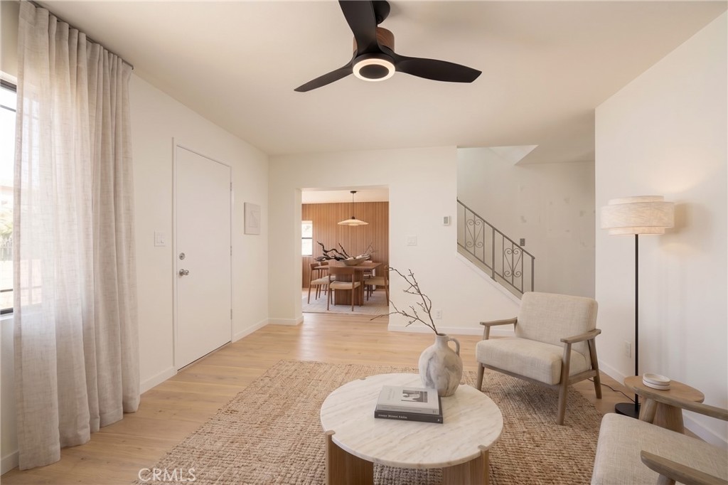 Living room with a round marble coffee table and dining area visible beyond.