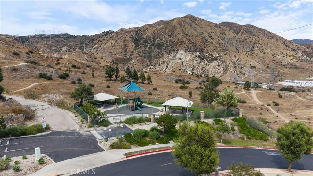 Neighborhood park with a playground and shade canopies below dry hills.