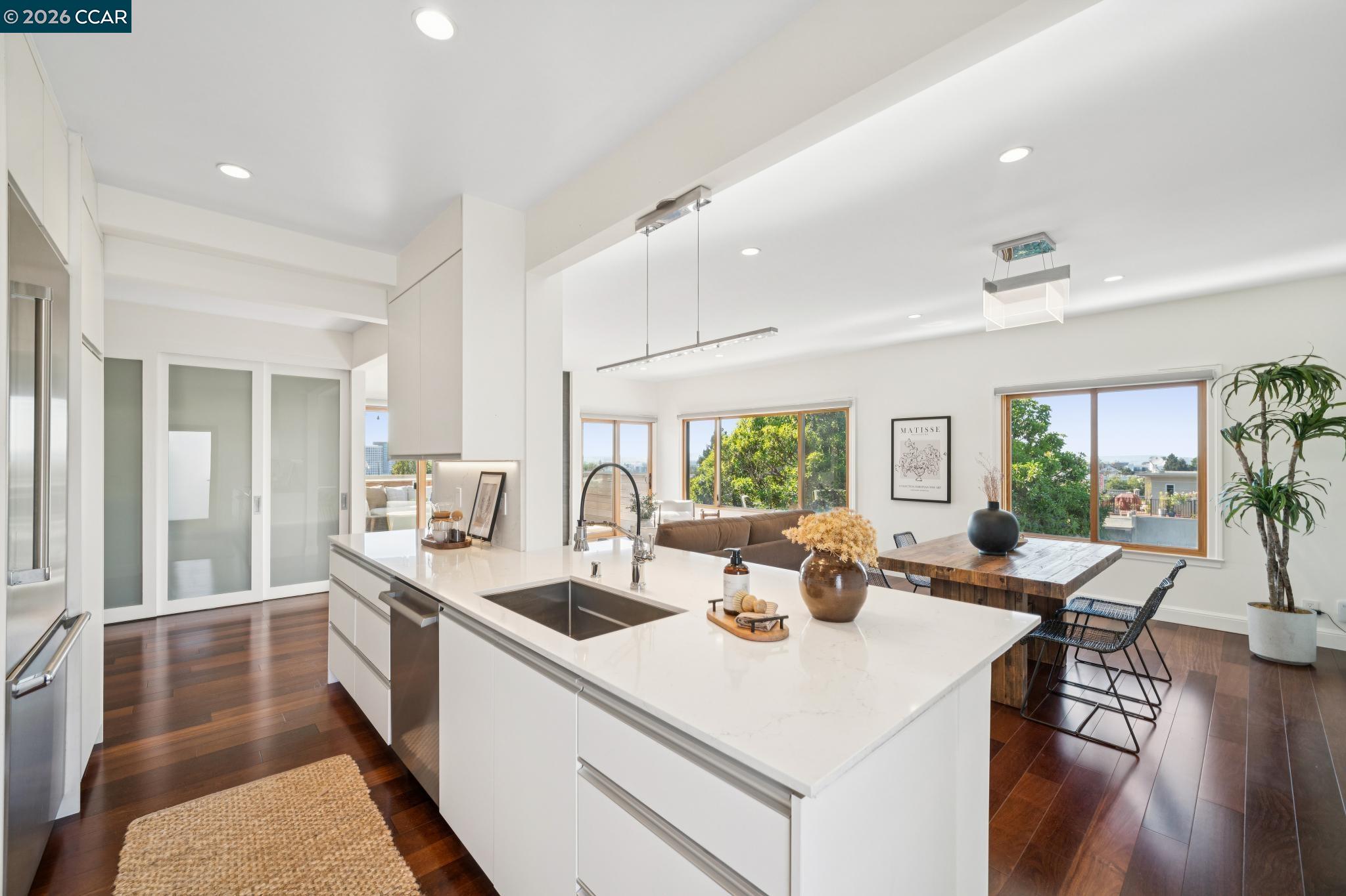 Open-plan kitchen with a large white island, adjoining dining area, and wide windows.