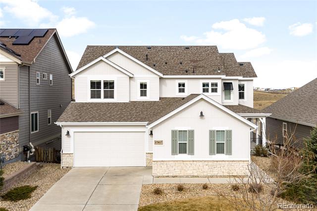 White two-story house with gray shutters, stone accents, and an attached garage.