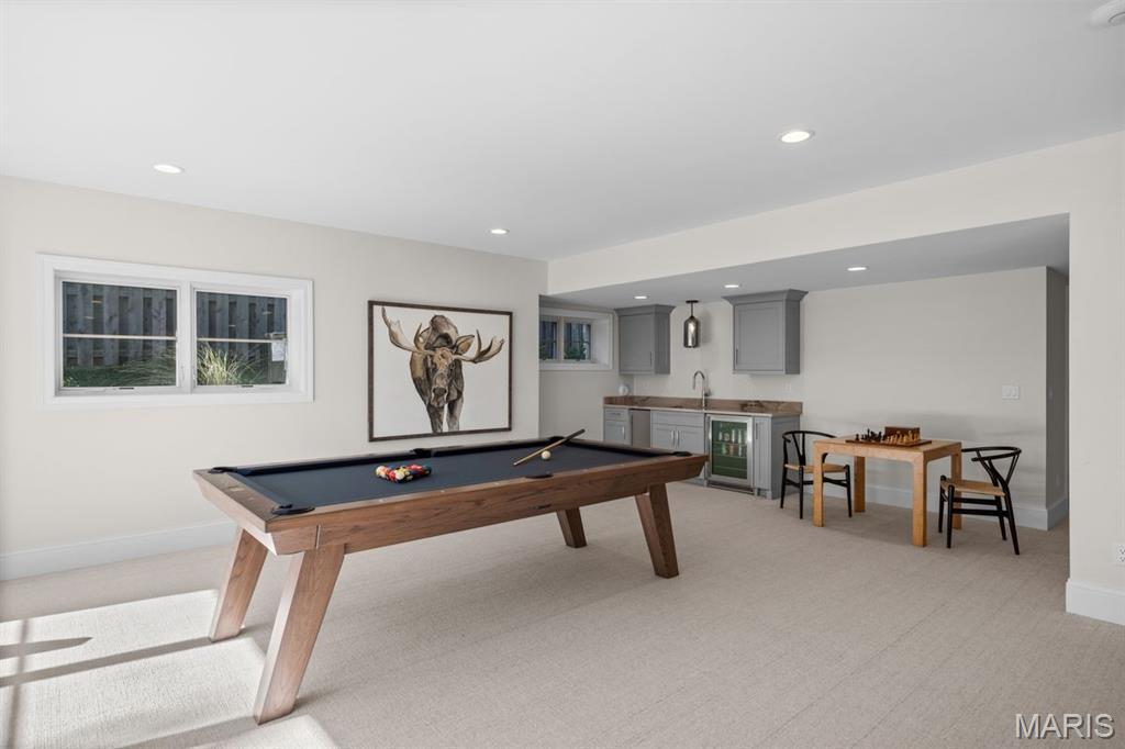 Recreation room with a pool table, gray kitchenette, and chess table.