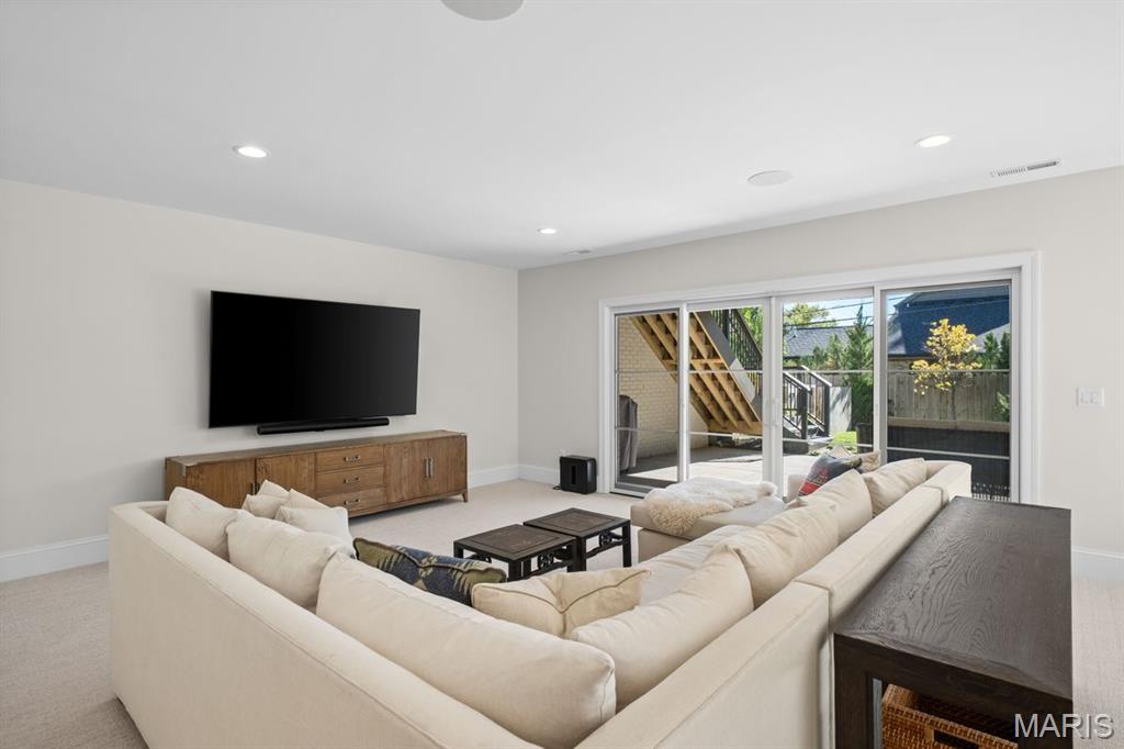 Living room with a cream sectional, wall-mounted TV, and sliding glass doors to the patio.