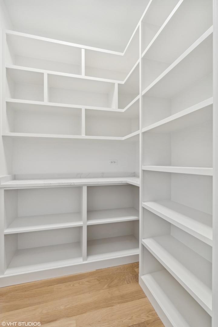 Room with extensive white built-in shelving, open cubbies, and a countertop.