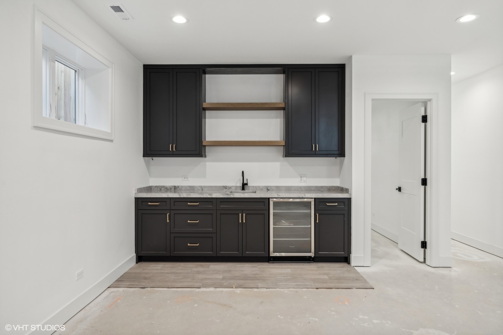 Kitchen with dark cabinetry, open wood shelves, a stone countertop, and a built-in beverage refrigerator.