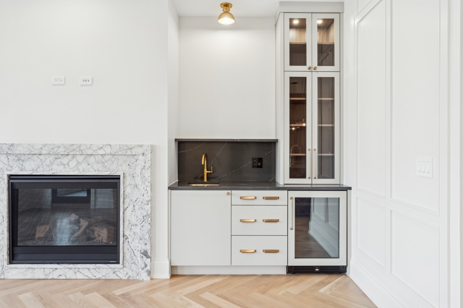 Fireplace and built-in wet bar with glass-front cabinets and wine refrigerator.