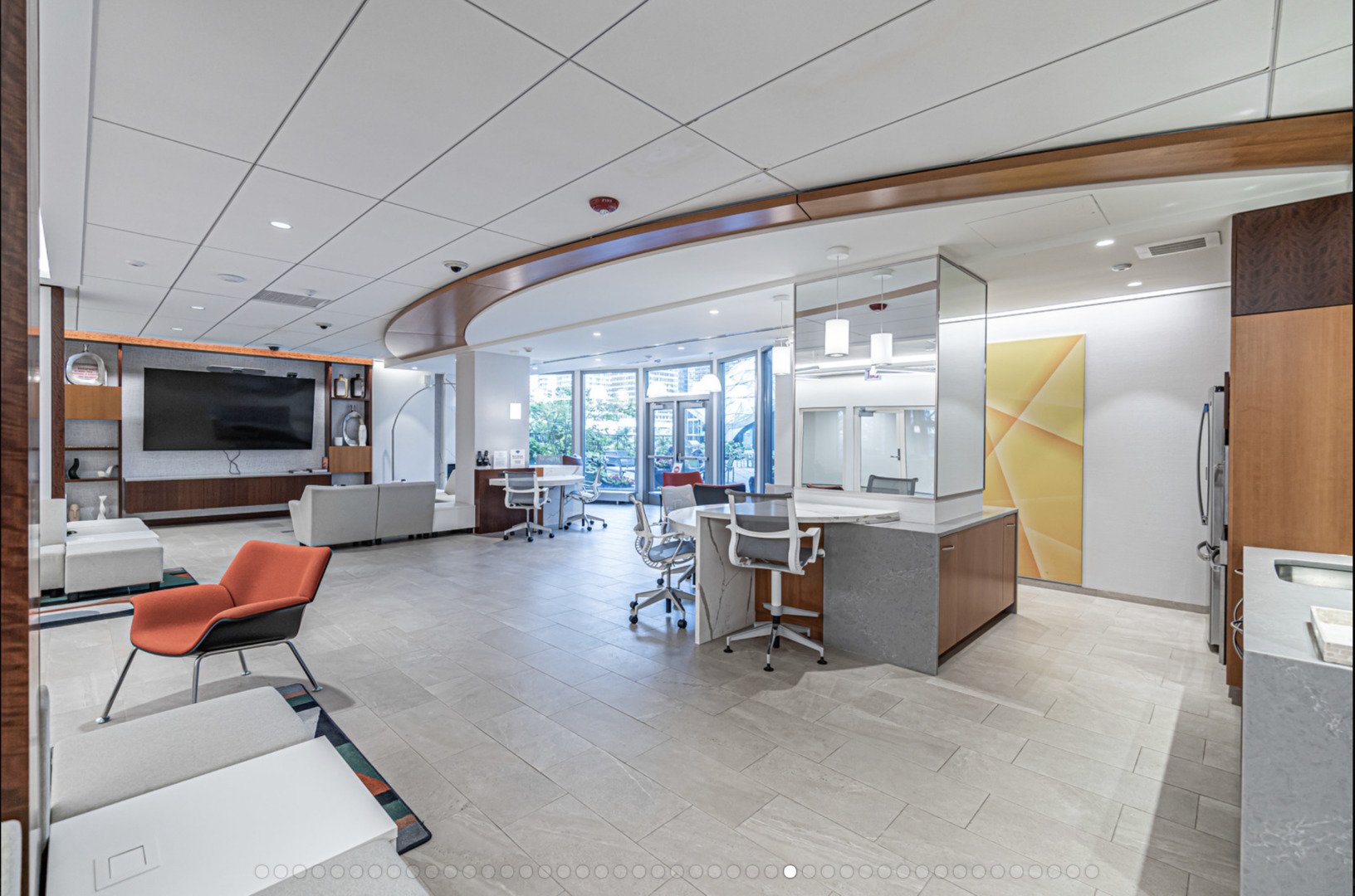 Condominium lobby lounge with a reception counter, work tables, and a bright red chair.
