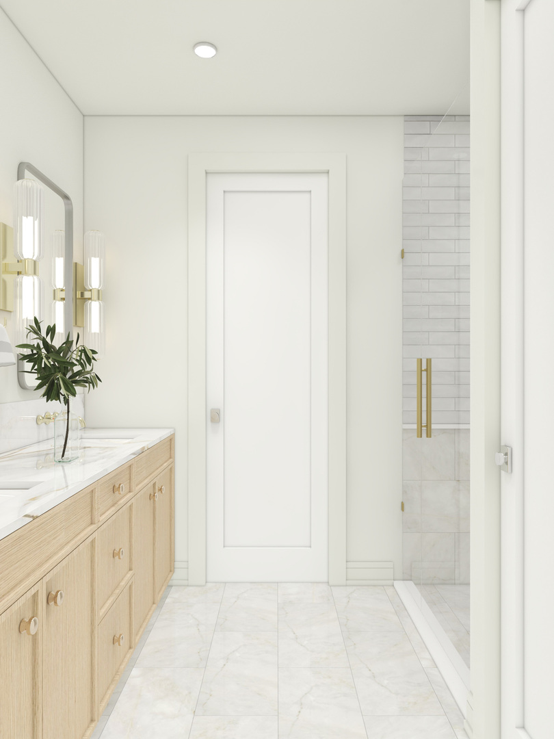 Bathroom with a light wood vanity and a tiled shower with brass hardware.