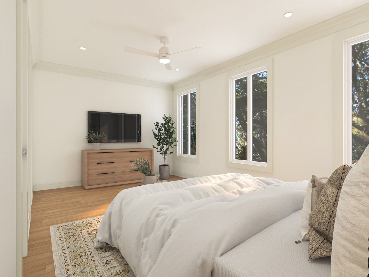 Bright bedroom with a white bed, light wood floors, and tall windows overlooking trees.