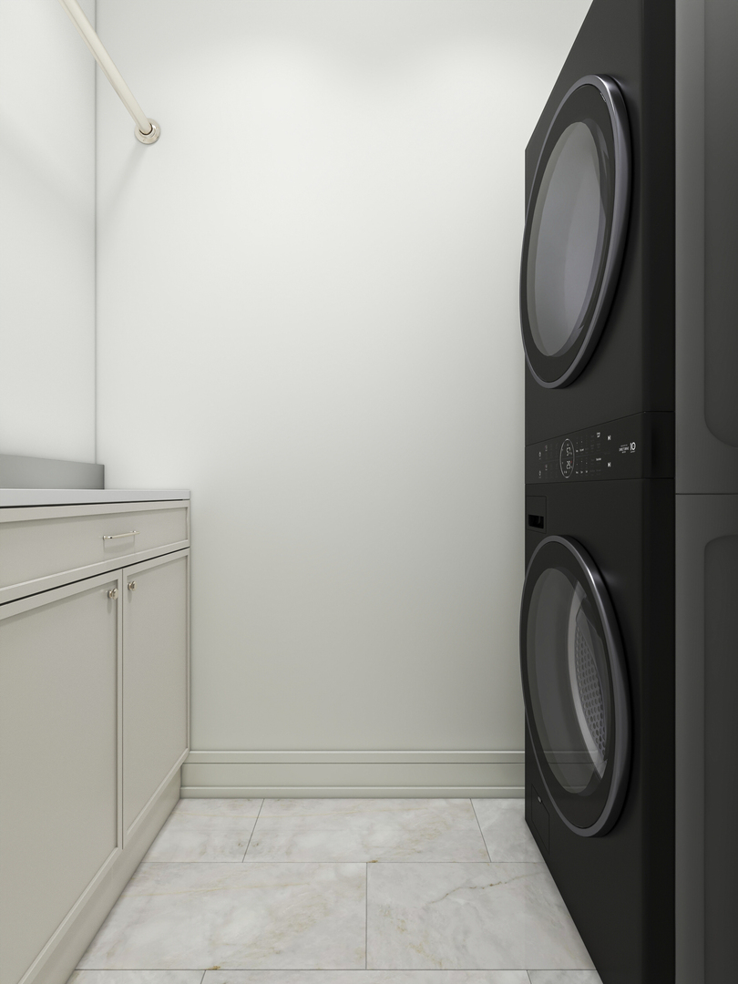 Laundry room with a black stacked washer and dryer beside white cabinetry.