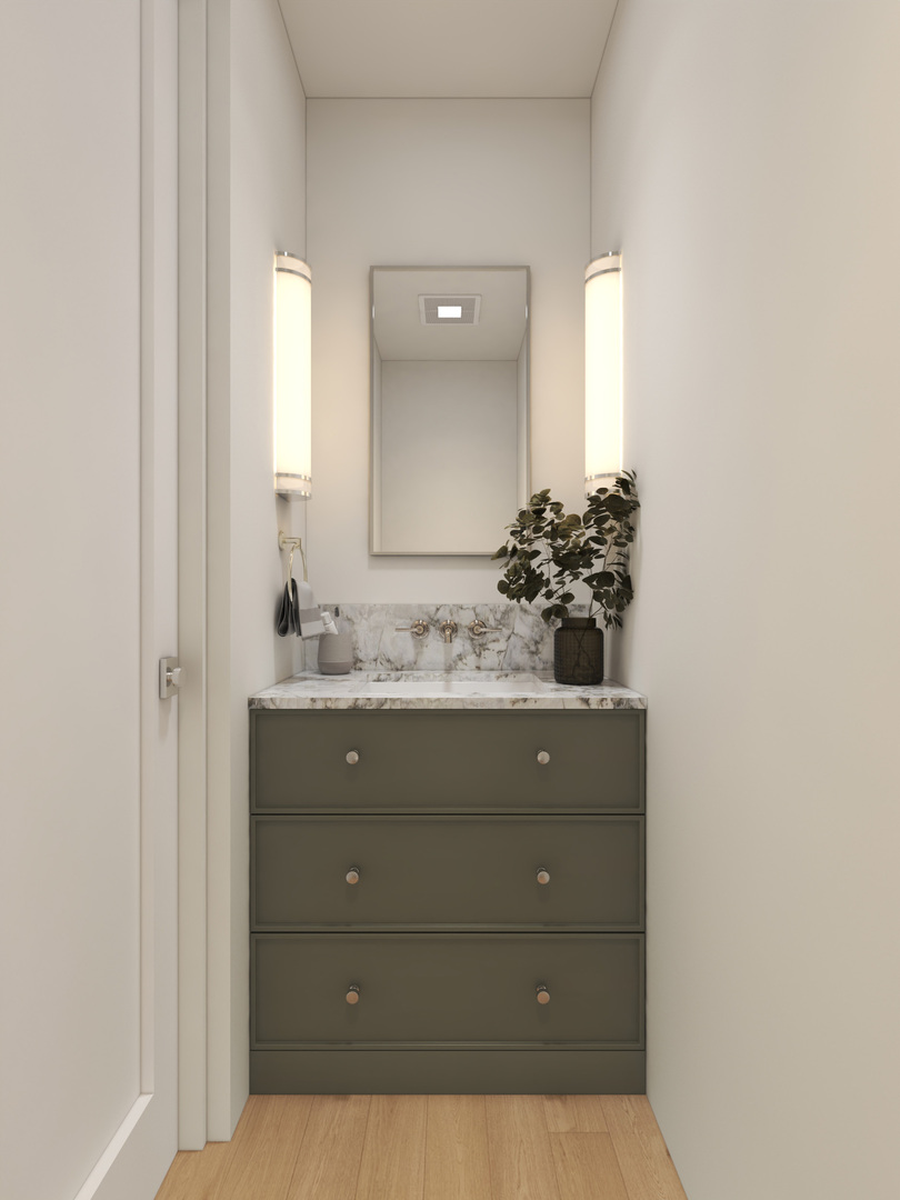 Bathroom vanity with gray drawers, marble countertop, tall lit sconces, and a potted plant.