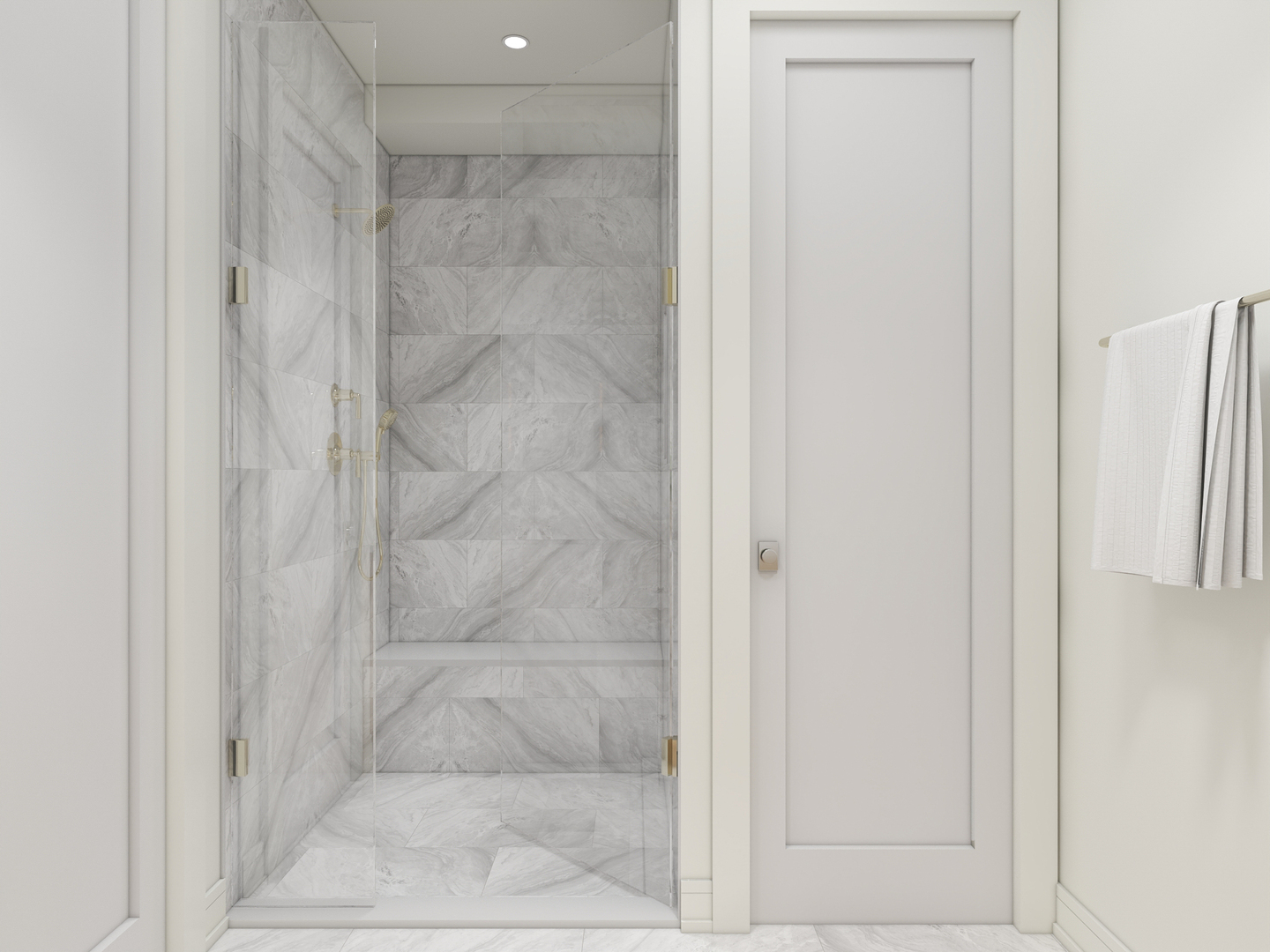Marble-tiled bathroom shower with brass fixtures, a built-in bench, and white towels nearby.
