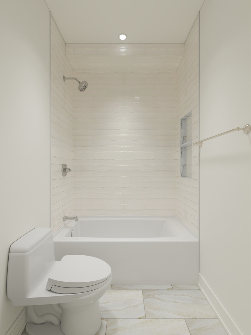 Bathroom with a white bathtub, tiled shower surround, recessed niche, and toilet.