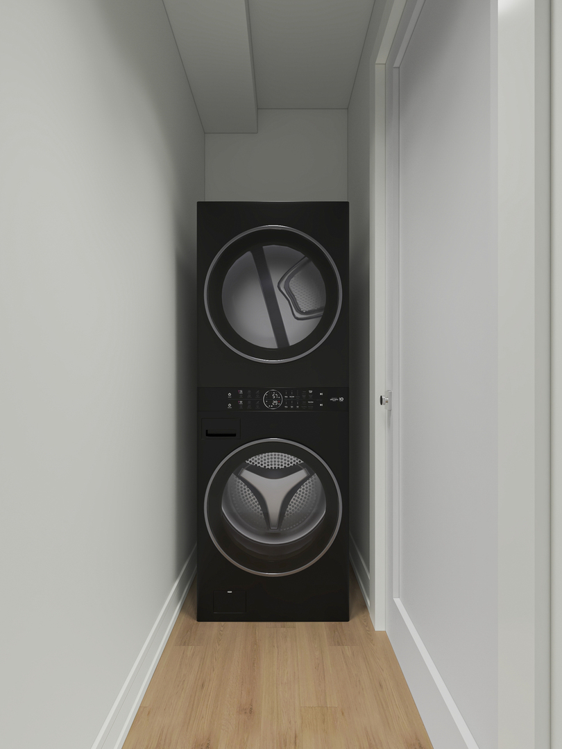 Black stacked washer and dryer in a narrow laundry closet with light wood flooring.