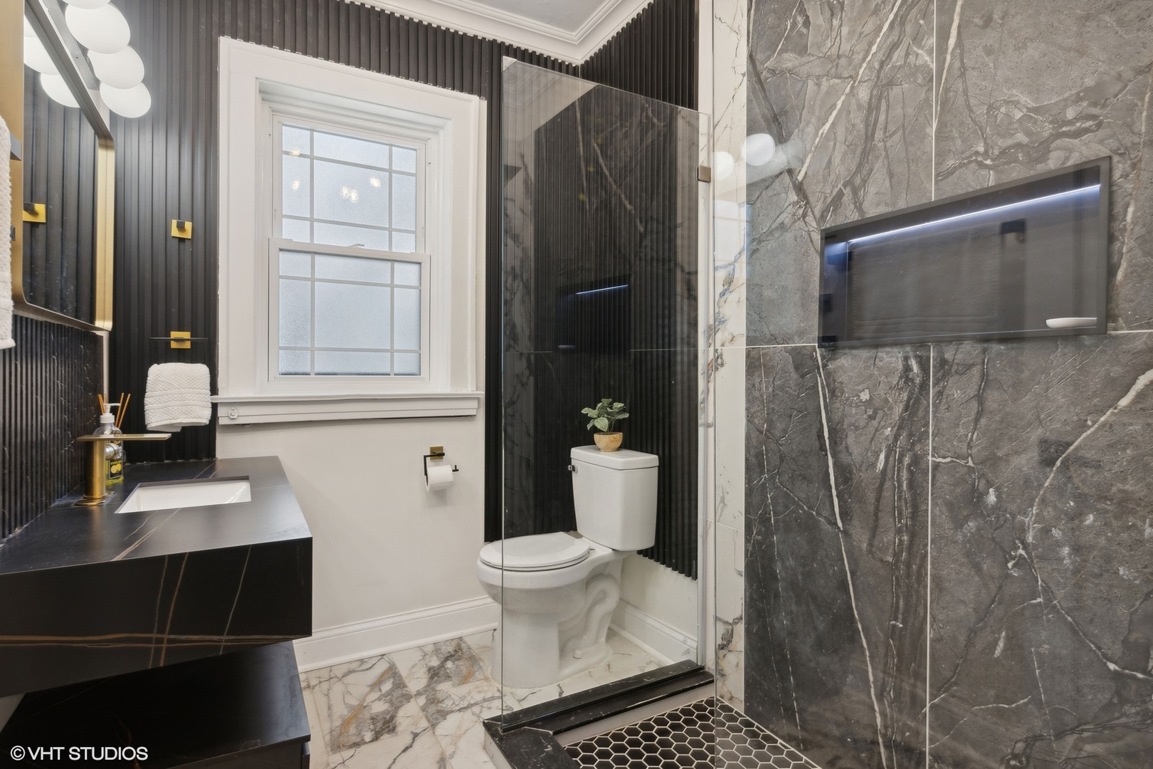 Bathroom with a black floating vanity, glass-enclosed shower, and dramatic gray veined tile.