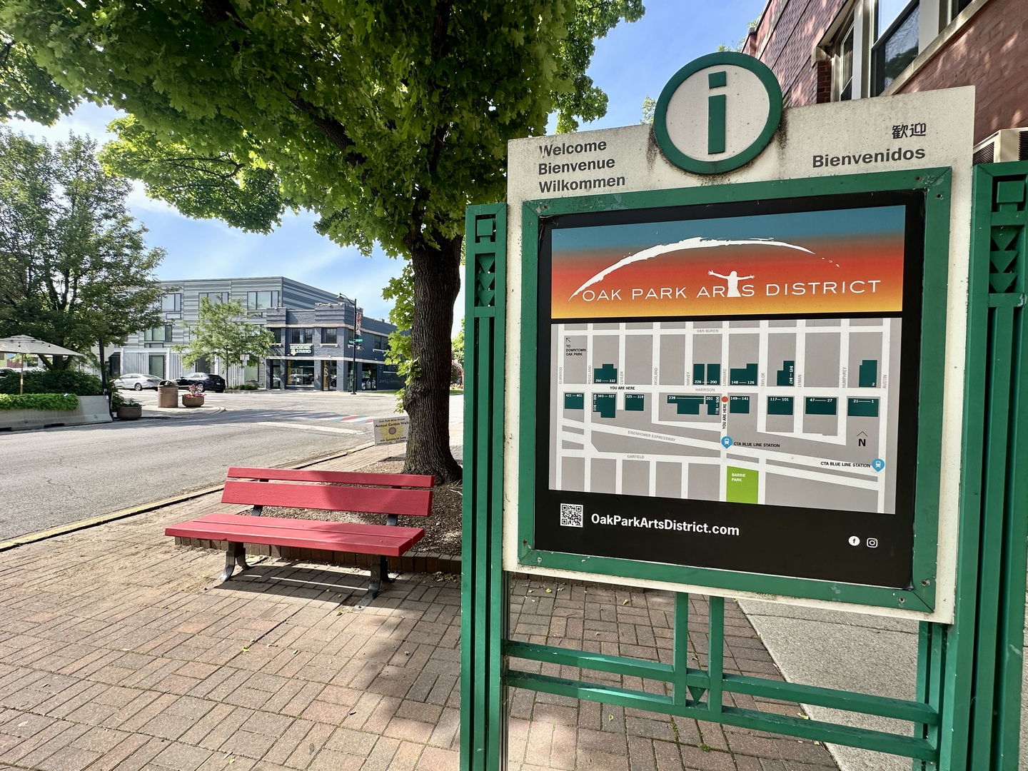 Oak Park Arts District welcome sign and neighborhood map beside a red bench.