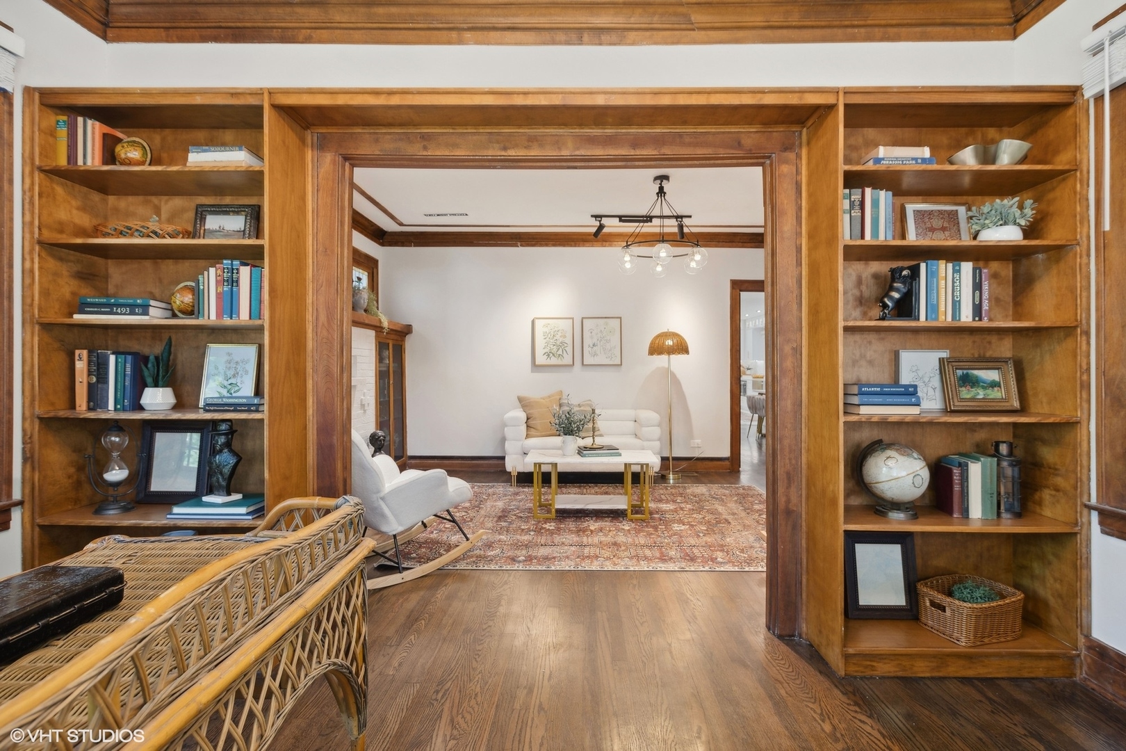 Living room with built-in wooden bookshelves framing a second sitting area with a white sofa.