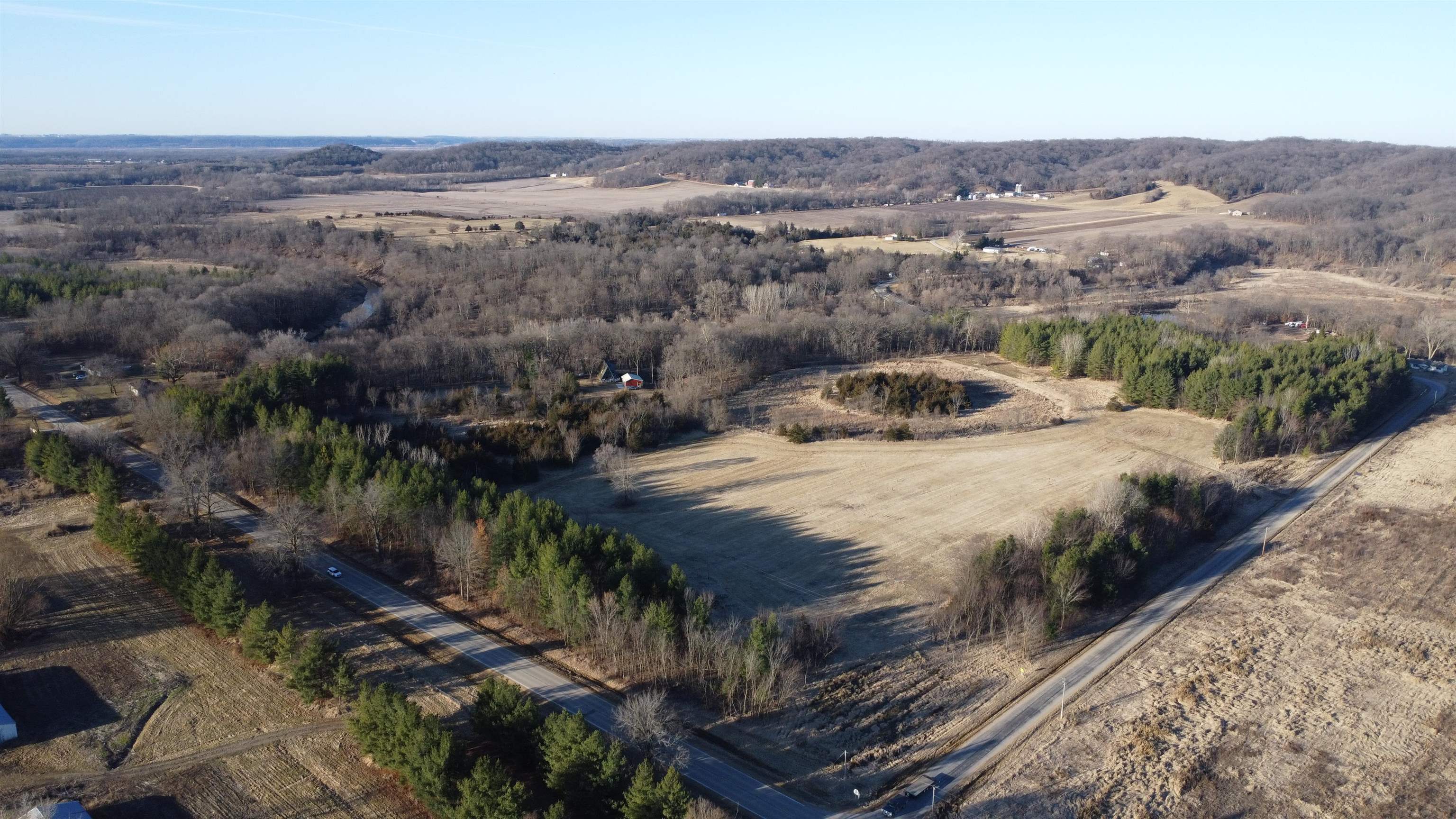 Aerial view of open land bordered by wooded areas and rural roads.