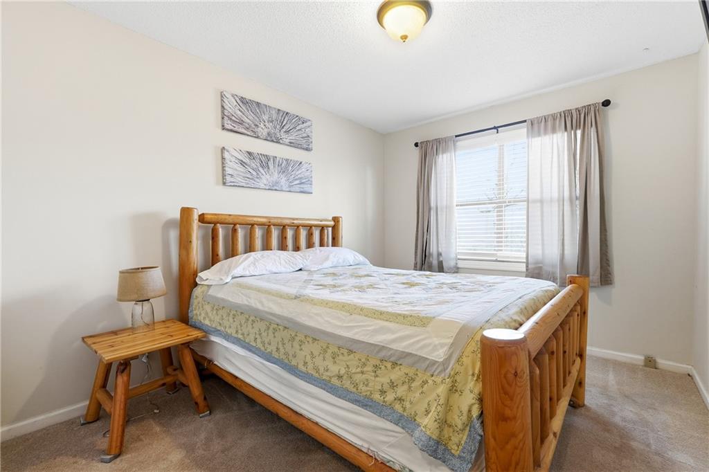 Bedroom with a log-style wooden bed and curtained window.